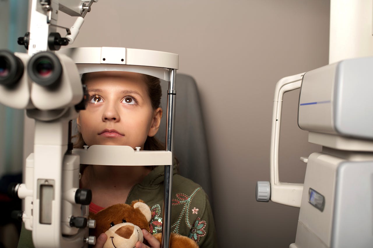 Young girl undergoing an eye examination with advanced optometry machinery.